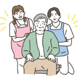 車椅子に乗る高齢者男性と男女の介護士